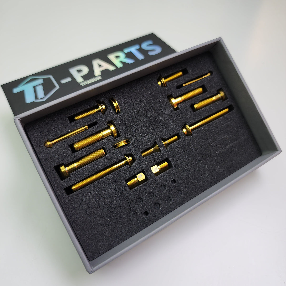 Gold titanium bolts and fittings for a SRAM AXS upgrade kit in a foam case