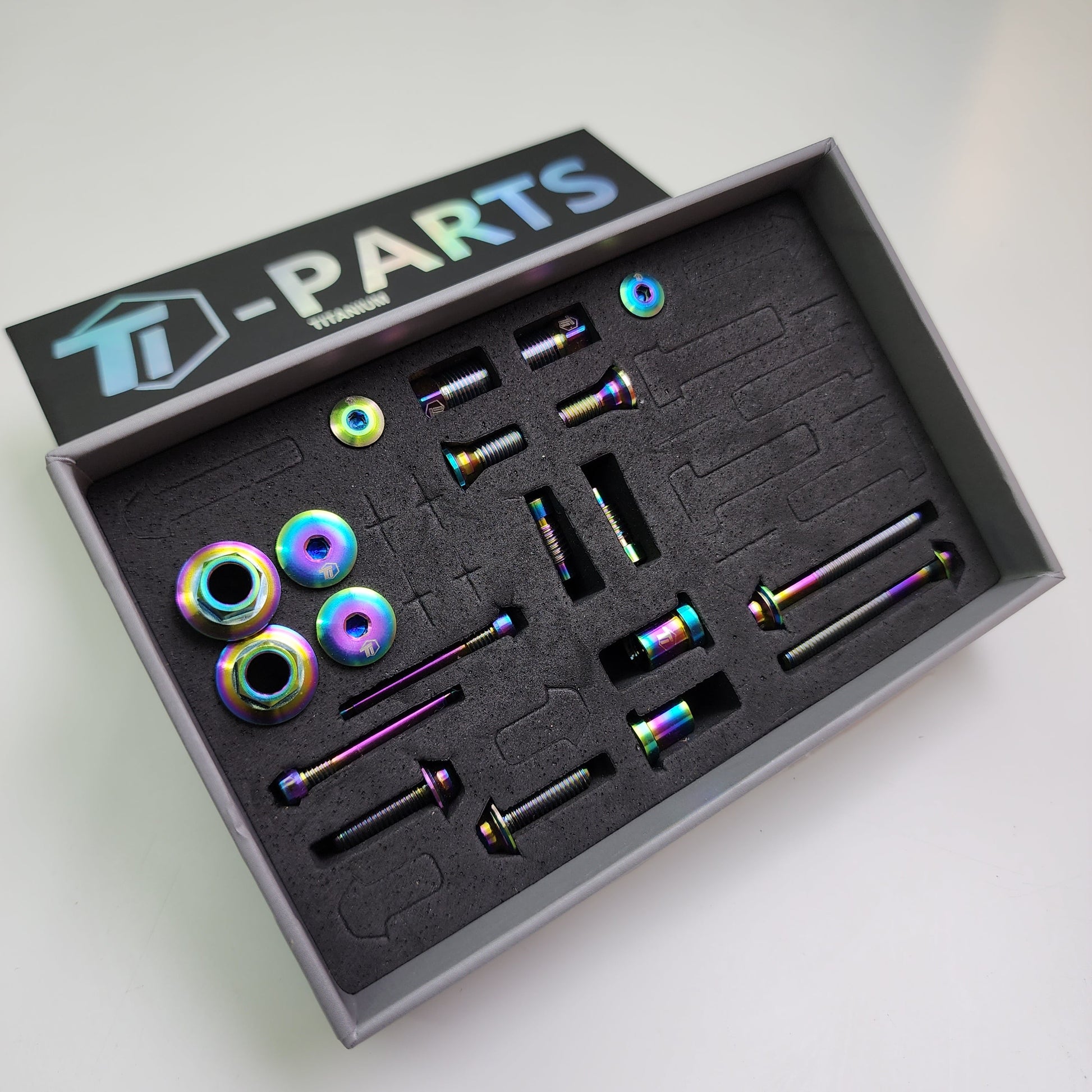 Rainbow oil slick titanium Shimano 12-speed groupset upgrade hardware in foam tray