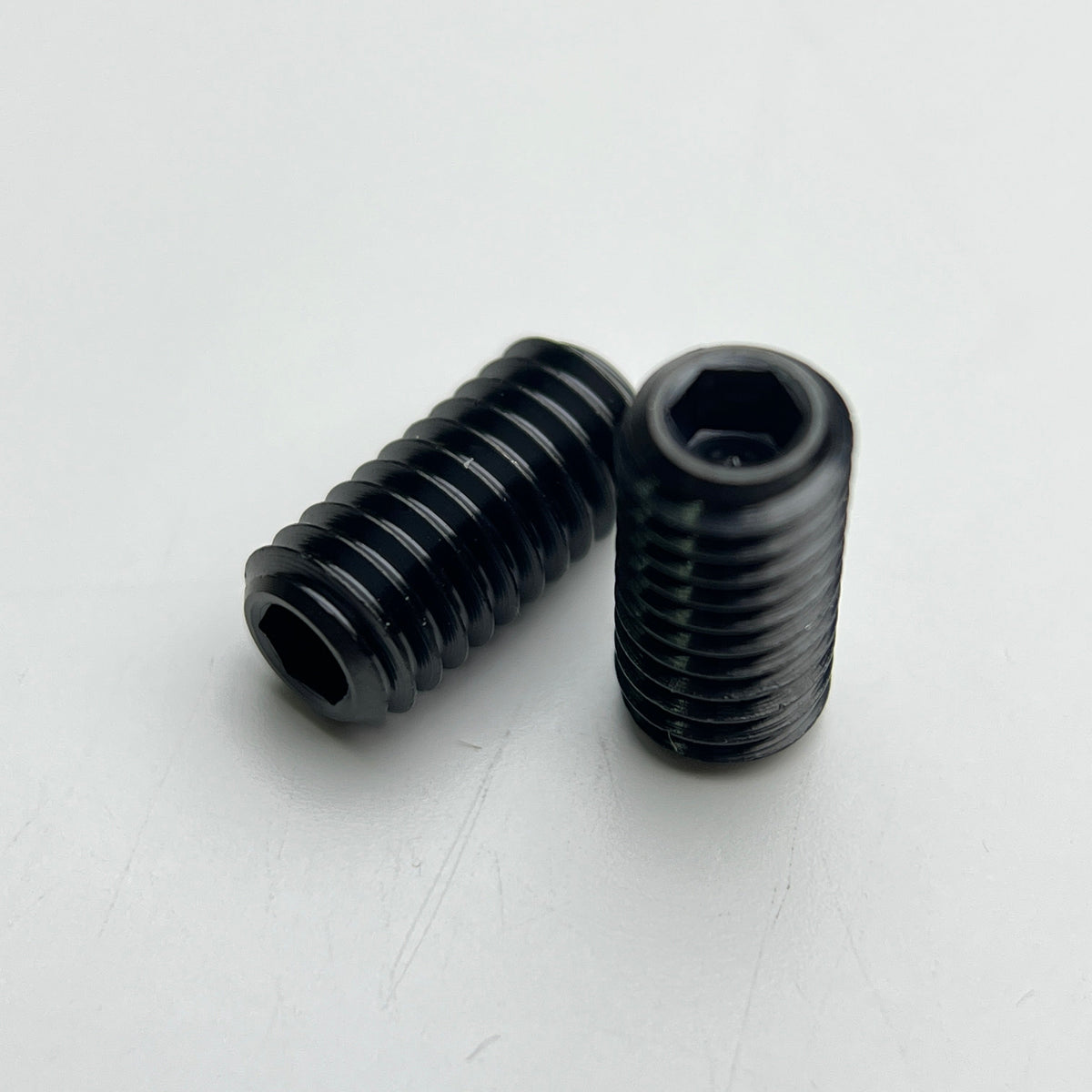 Two nitride black Pinarello seatpost screws shown at an angle