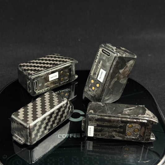 Four carbon fiber vape devices with a black and gray woven pattern, displayed on a black reflective scale against a dark background.