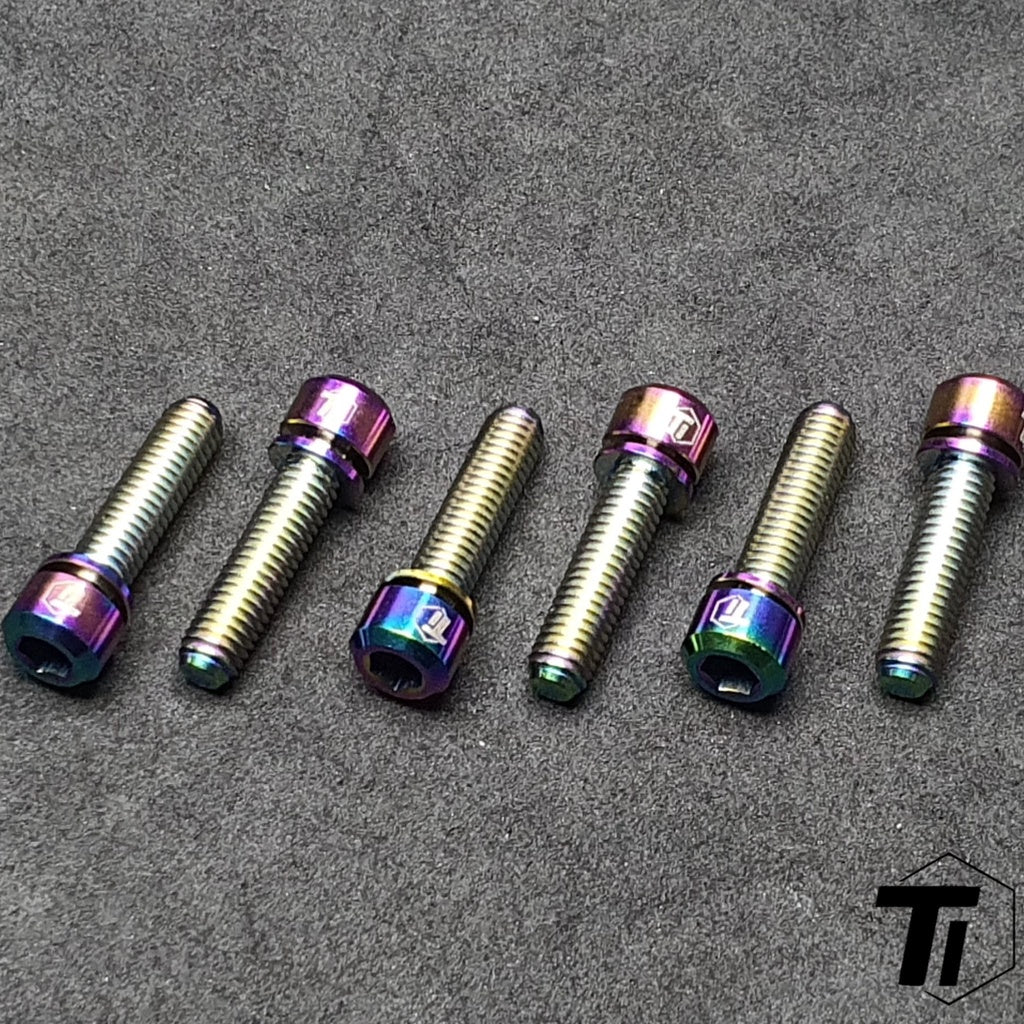 Close-up arrangement of oil-slick titanium Specialized Trail stem bolts
